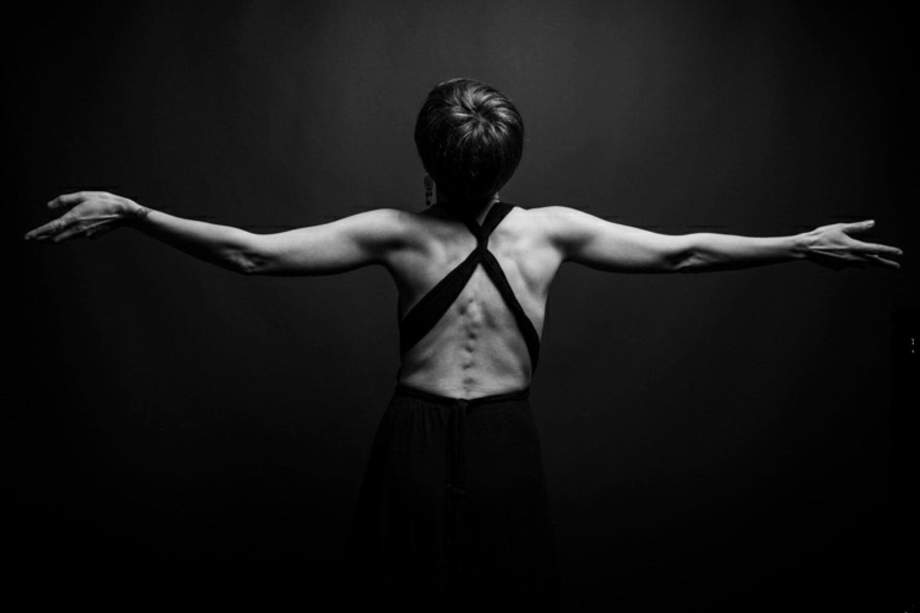Silhouette de dos, bras ouverts, en noir et blanc